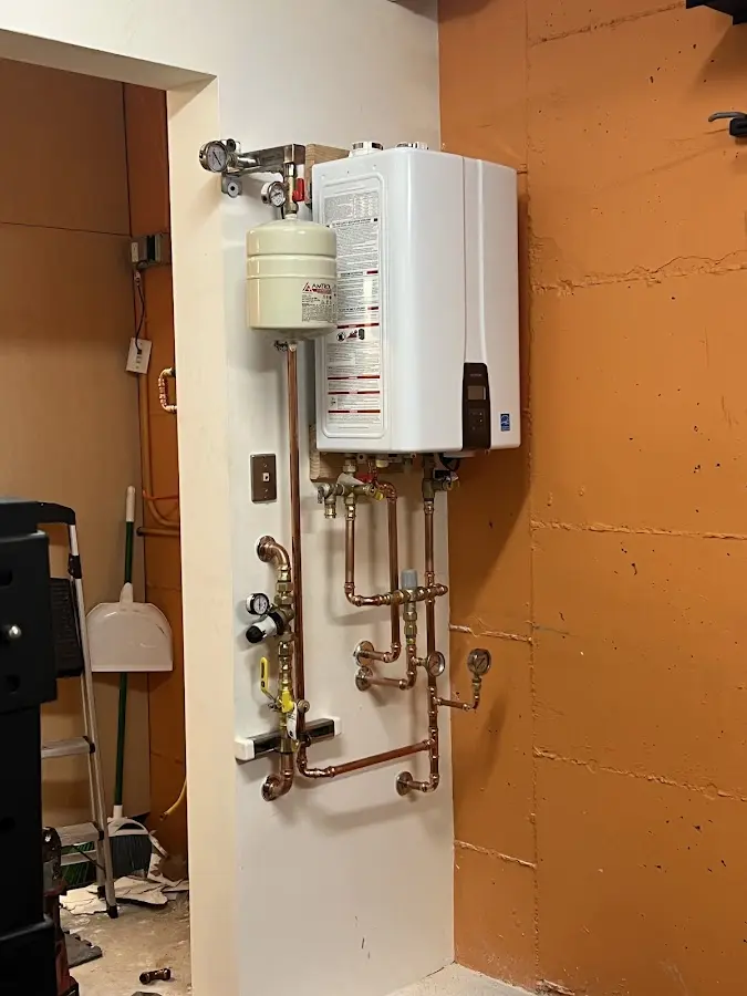 Plumbing technician inspecting water heater connections in Floris